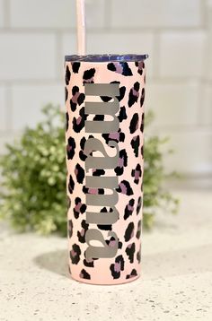 a pink and black leopard print tumbler with a straw