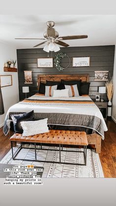 a bedroom with a bed, bench and ceiling fan in the middle of the room