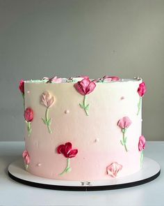 a white cake with pink frosting and flowers on it