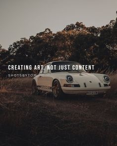 a white car sitting in the middle of a field with trees behind it and a quote about creating art not just content