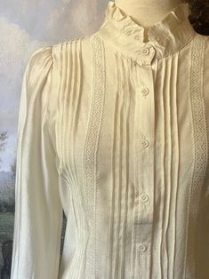 This is the quintessential button-up blouse of the 19th-century, featuring lightweight polished cotton, a high neck ruffled collar, pintuck pleats on the bodice, long button-cuffed sleeves with ruffle hem, and crochet lace trim. Use it as the base of any Victorian or Edwardian era look for tip-top historical accuracy! Sizing: ✧IN Bust Waist Sleeve LxW Length S 38 In. 40 In. 23x14 In. 21 In. M 40 In. 42 In. 23x14 In. 21.5 In. L 42 In. 44 In. 24x15 In. 22 In. XL 44 In. 46 In. 24x15 In. 22.5 In. ✧C Neck Ruffle Collar, Pintuck Pleats, Fantasy Shop, Fashion School, 2024 Style, Crochet Lace Trim, Medieval Fashion