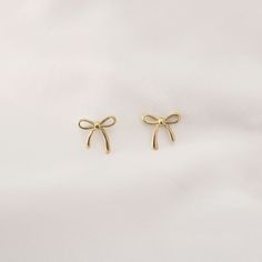 Dainty Ribbon Stud Earrings   - This listing is for pair os the Dainty Ribbon Stud Earring. Perfect for everyday and layering - Base Material: High Quality Stainless Steel - Measurement: Length - 4mm, Width - 5mm - Finish: 18K Gold - Nickel Free and Tarnish Free - All our jewelry is packaged in gift ready boxes. If you would like multiple items from your order packaged separately please let us know! © 2024 Generation of Daughters Coquette Earing, Ribbon Earring, Coquette Earrings, Dainty Coquette, Coquette Ribbon, Ribbon Earrings, Earrings Aesthetic, Golden Jewelry, Gold Stud Earrings