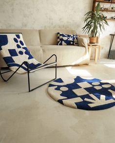 a blue and white rug sitting on top of a floor next to a couch in a living room