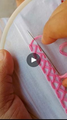 someone is working on something with pink thread and scissors in the process of stitching