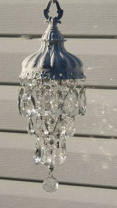 a chandelier hanging from the side of a wooden wall