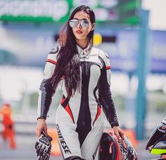 a woman in white and black riding on the back of a motorbike while wearing goggles