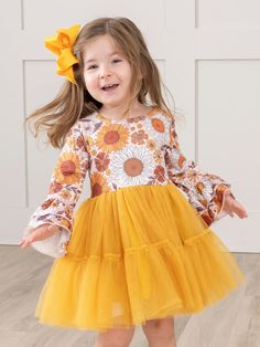 Say hello to autumn with our Golden Sunflowers Bell Sleeve Tulle Dress for girls! This unique dress features a sunflower bodice and tiered bell sleeves, paired with a delicate tiered tulle skirt. Perfect for twirling and adding a touch of sunshine to any occasion. Fits true to size. 95% Polyester/ 5% Spandex Combo: 100% Polyester Accessories sold separately. Suggest bow color #16 & #57 Import. *Afterpay and Sezzle Purchase Requires $35 Minimum Order. Tiered Tulle Skirt, To Autumn, Unique Dress, Dress For Girls, Unique Dresses, Tulle Dress, Bell Sleeve, Say Hello, Tulle Skirt