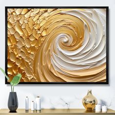 an abstract gold and white painting hangs on the wall above a table with vases