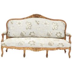 an old fashioned couch with floral fabric on it's back and armrests