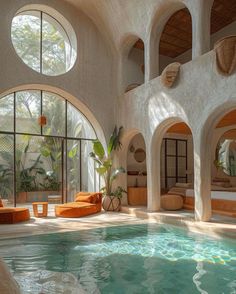 an indoor swimming pool with circular windows and round seating area in the center, surrounded by stone arches