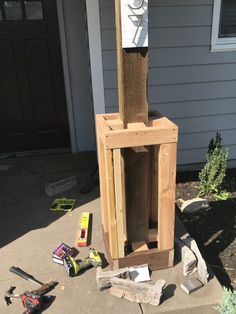 a bird house made out of wood with tools around it