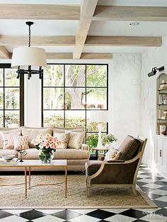 a living room with black and white checkered flooring, two couches, coffee table