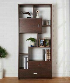 a bookshelf in the corner of a room next to a potted plant