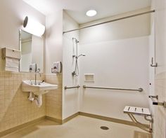 a bathroom with a shower, sink and mirror