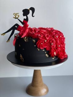 a cake decorated with red flowers and an image of a woman sitting on top of it