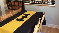 a black and yellow table cloth with a bat on it in front of a window