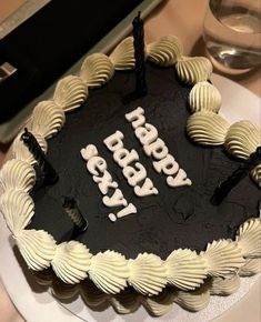 a black and white birthday cake sitting on top of a table