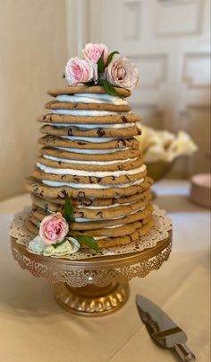 there is a cake made out of cookies and flowers on the table with utensils