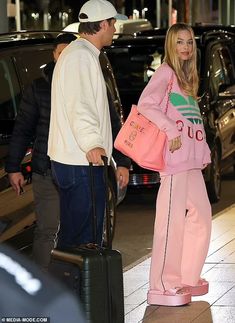 a man and woman standing next to each other with luggage