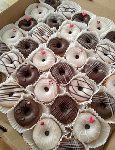 a box filled with lots of chocolate covered donuts