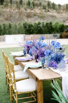 the table is set with purple and blue flowers