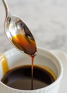 a spoon full of liquid being poured into a cup