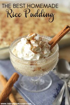 a dessert with whipped cream and cinnamon sticks in a small glass bowl on a blue napkin