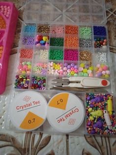 there are many beads and scissors in the plastic box on the table with it's contents