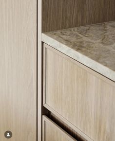 an image of a wooden cabinet with marble counter top and drawers on the left side