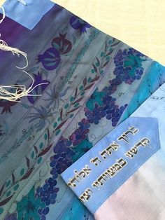 "A silk prayer shawl with matching bag for woman. This one of a kind Jewish woman's prayer shawl (also called tallit in Hebrew) is made of silk crepe satin 12.5mm. A painting of the Seven Species on a blue or lilac silk prayer shawl wraps you with the divine spirit and holiness. Buy this tallit for the girl who celebrates her Bat Mitzvah. Dimensions: 22\"/71\" (55 /180 cm) Materials: Silk crepe satin 12.5mm. Silk colors. Care: Hand wash, iron on the rear side. Can be ordered with the following t Baruch Atah Adonai, Divine Spirit, Silk Colors, Jewish Prayer, Jewish Women, Hand Painted Gifts, Prayer Shawl, Pad Bag, Jewish Gifts