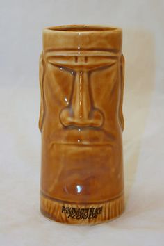 a brown ceramic cup with a face on it