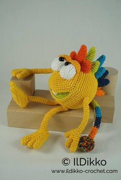 a crocheted toy sitting on top of a wooden block