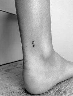 a black and white photo of a person's foot with a small tattoo on it