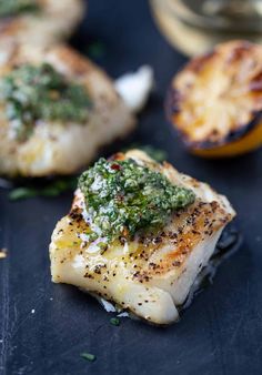 grilled fish with pesto on top and lemons in the background text reads homemade grilled god fish