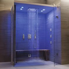 a shower with blue walls and flooring in a large bathroom area that has a bench under the shower head