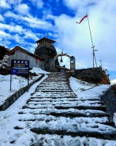 snow covered steps leading up to the top of a mountain with a flag on it