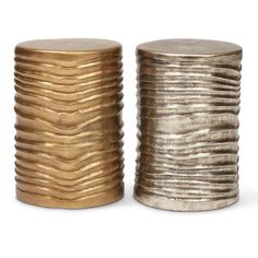 two gold and silver metal stools with wavy design on the top one has a round lid