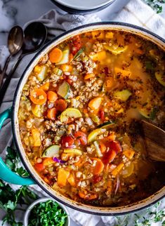 a pot filled with soup and vegetables on top of a table