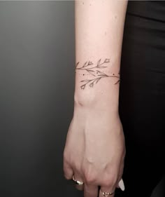 a woman's hand with a small tattoo on the wrist and an arrow in the middle