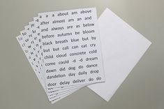 four pieces of white paper with words on them sitting next to each other in front of a gray background