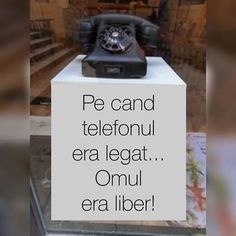 an old fashioned telephone sitting on top of a white sign that reads pe cand telefonul era legat omu era liber