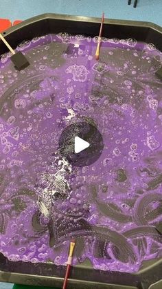 a pan filled with purple liquid and sticks sticking out of the top to dry it