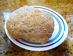 a sesame seed doughnut on a blue and white plate