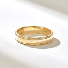 two yellow gold wedding bands sitting on top of each other