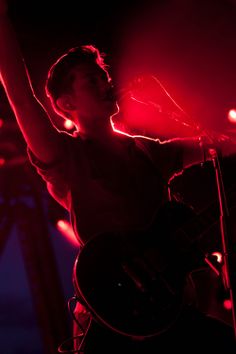 a man holding a guitar up in the air