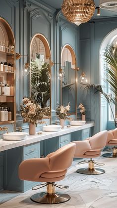 the interior of a salon with blue walls and marble countertops, gold accents and pink chairs