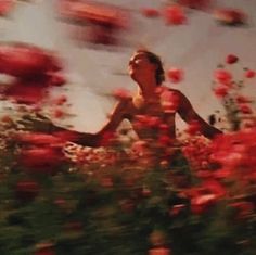 a woman running through a field of flowers