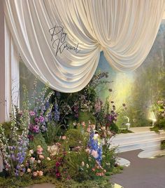 a floral display with white drapes and flowers