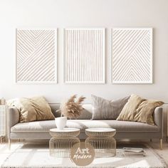 a living room with three paintings on the wall and two coffee tables in front of it