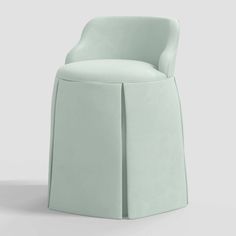 a light green chair sitting on top of a white floor